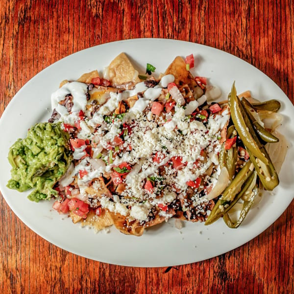Avocados Mexican Grill's nachos with guacamole, pico de gallo, cheese, sour cream, and pickled jalapeños.